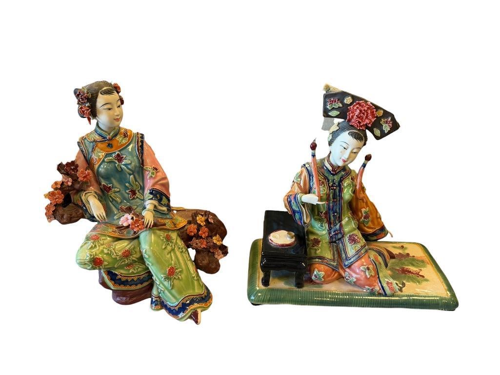 CHINA SHIWAN WUCAI CERAMIC FEMALE FIGURES: FIGURE OF A WOMAN SITTING DOWN NEXT TO TEA TABLE AND OTHER OF A WOMAN SEATED ON CHERRY BLOSSOM TRUNK, ONE FIGURE HAS DAMAGED FINGERS AND MISSING TEA CUP, BOTH MARKED ON THE BOTTOM 8 1/2" AND 9" H