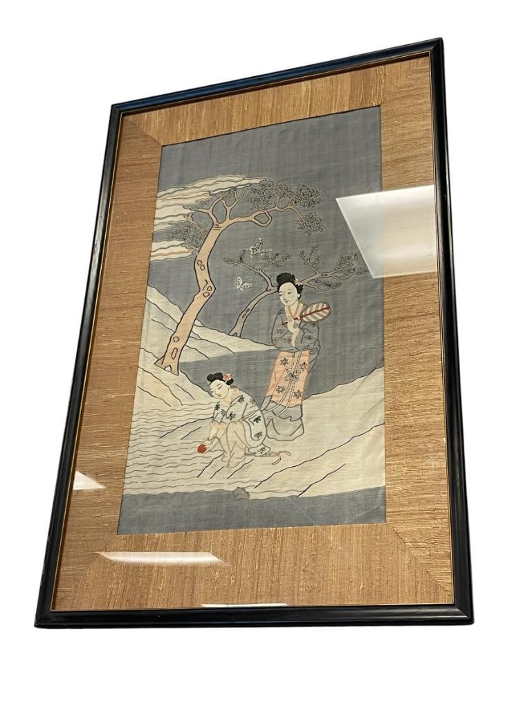 20TH CENTURY HAND EMBROIDERED JAPANESE SILK PANEL: SILK PANEL DEPICTS TWO WOMAN / GEISHA NEAR A BODY OF WATER WITH TREES IN THE BACKGROUND, FRAMED 25" X 38 1/2" FRAME 