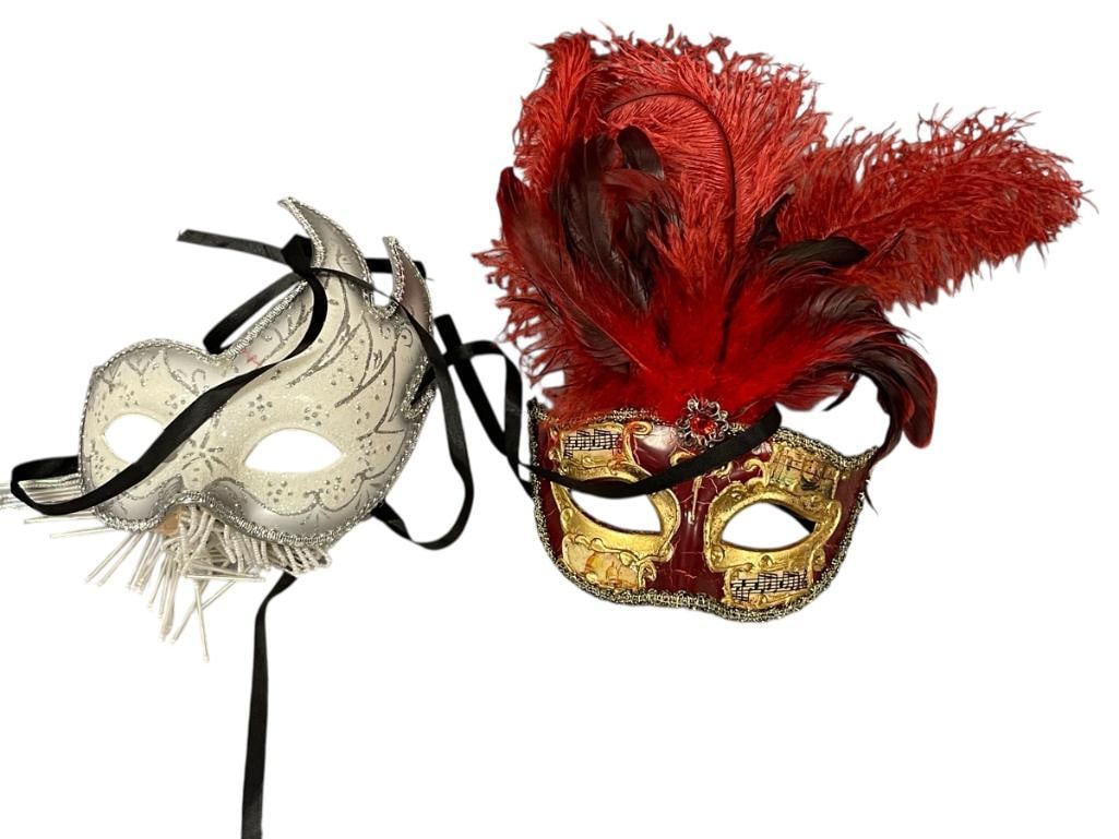 TWO HAND CRAFTED VENETIAN MASQUERADE MASKS: WHITE AND SILVER MASK WITH HANGING BEADED FRINGE AND RED AND GOLD MASK DECORATED WITH FEATHERSMUSICAL NOTES AND CITY ILLUSTRATIONS 6 1/2" X 8" AND 6 1/2" X 12" 