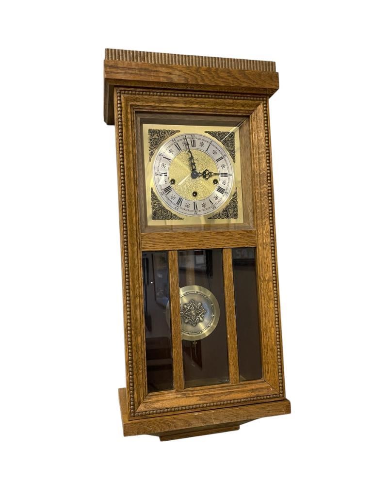 VINTAGE GERMAN MADE OAK 8-DAY WALL CLOCK: FEATURES BRASS AND NICKEL FINISH DIAL WITH ROMAN NUMBERS, INCLUDES WIND-UP KEY, IN WORKING CONDITION 12" X 8" X 28"