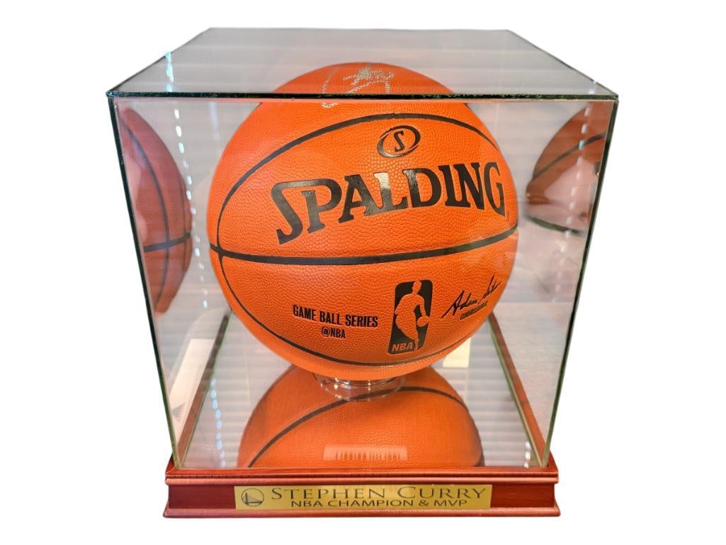 STEPHEN CURRY 4X-NBA CHAMPION AUTOGRAPHED BASKETBALL AUTHENTICATED BY SPORTS GALLERY: SPALDING BASKETBALL SIGNED BY STEPHEN CURRY, AUTHENTICATED BY SPORTS GALLERY NO. 5405, LETTER AND AUTHENTICATION INCLUDED, BASKETBALL DISPLAY INCLUDED WITH MIRRORED BOTTOM, SQUARE GLASS DOME, AND