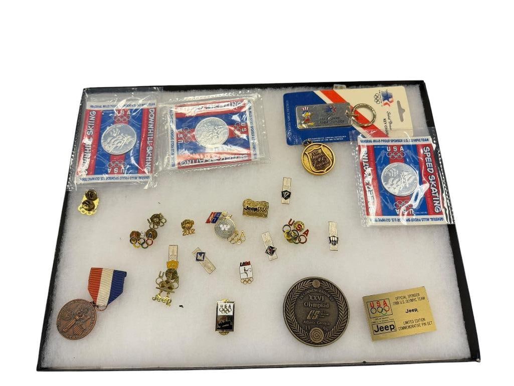 ASSORTED U.S. OLYMPIC SOUVENIR PINS AND MEDALS INCLUDING PINS DATING BACK TO 1980: ENAMELED DESIGNS, SILVER TONE COINS SPEED SKATING, DOWNHILL SKIING, 1984 LOS ANGELES OLYMPIC KEYCHAIN, U.S.A. DESIGNS, 1996 ATLANTA, GEORGIA BRASS COMMEMORATIVE MEDAL, AND MORE