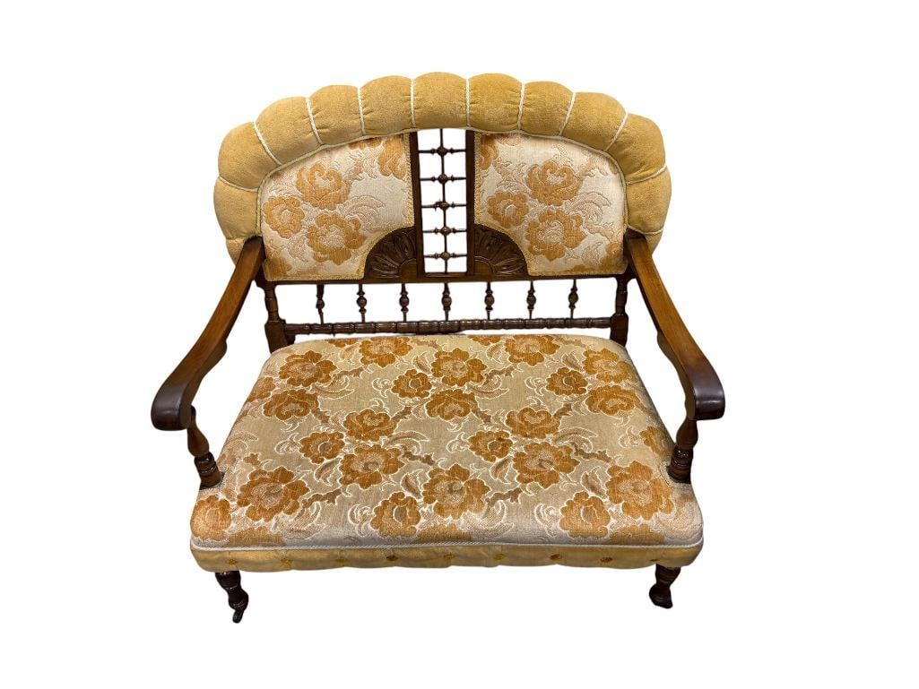 ANTIQUE VICTORIAN EASTLAKE WALNUT FRAMED SETTEE BENCH FEATURING YELLOW FLORAL UPHOLSTERY: CARVED WOOD FRAME WITH ELEGANT DARK STAIN, OVERALL GOOD CONDITION WITH SOME STAINING TO UPHOLSTERY, ON CASTORS 38" X 23" X 14 SEAT HEIGHT, 38" SEAT BACK HEIGHT