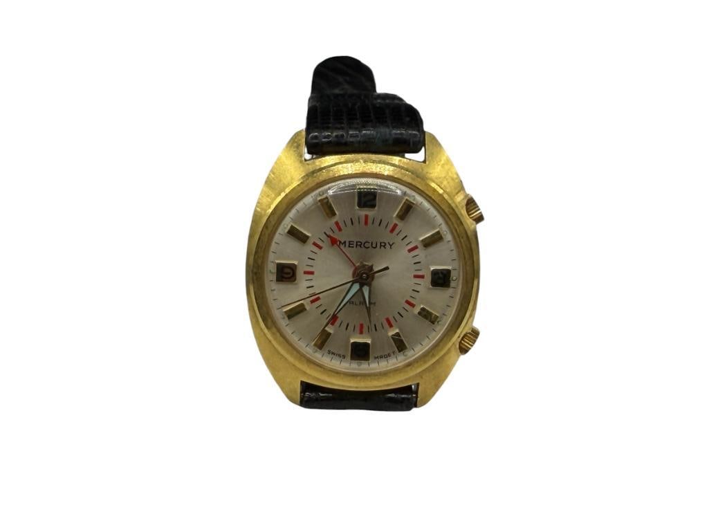 VINTAGE MERCURY SWISS MADE MANUAL WIND MECHANICAL WRISTWATCH WITH ALARM: MULTI-TONE FACE, GOLD TONE CASE WITH STAINLESS STEEL BACK AND LEATHER BAND, IN RUNNING CONDITION, SHOWS SIGNS OF WEAR36MM CASE 