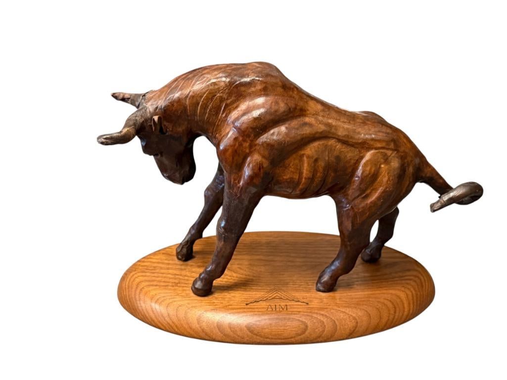 VINTAGE FULL LEATHER WRAPPED BULL FIGURE MOUNTED ON WALNUT BASE: ENGRAVED ON THE BASE "AIM", LIGHT WEAR ON ONE OF THE HORNS 6 3/4" H, 9 1/2" L
