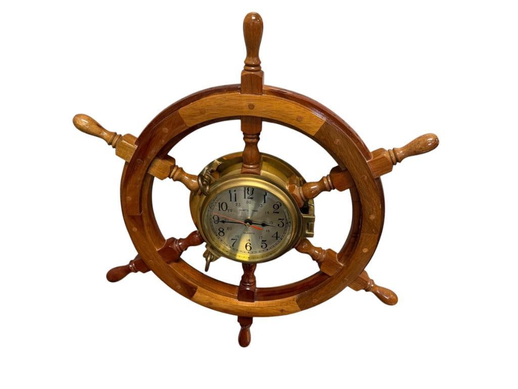 DECORATIVE NAUTICAL SHIP'S WHEEL WITH BRASS PORTHOLE CLOCK SHIP'S TIME MARITIME WALL CLOCK: LIGHTLY VARNISHED SHIPS WHEEL, POLISHED BRASS PORTHOLE CLOCK, BATTERY OPERATED 24" ROUND