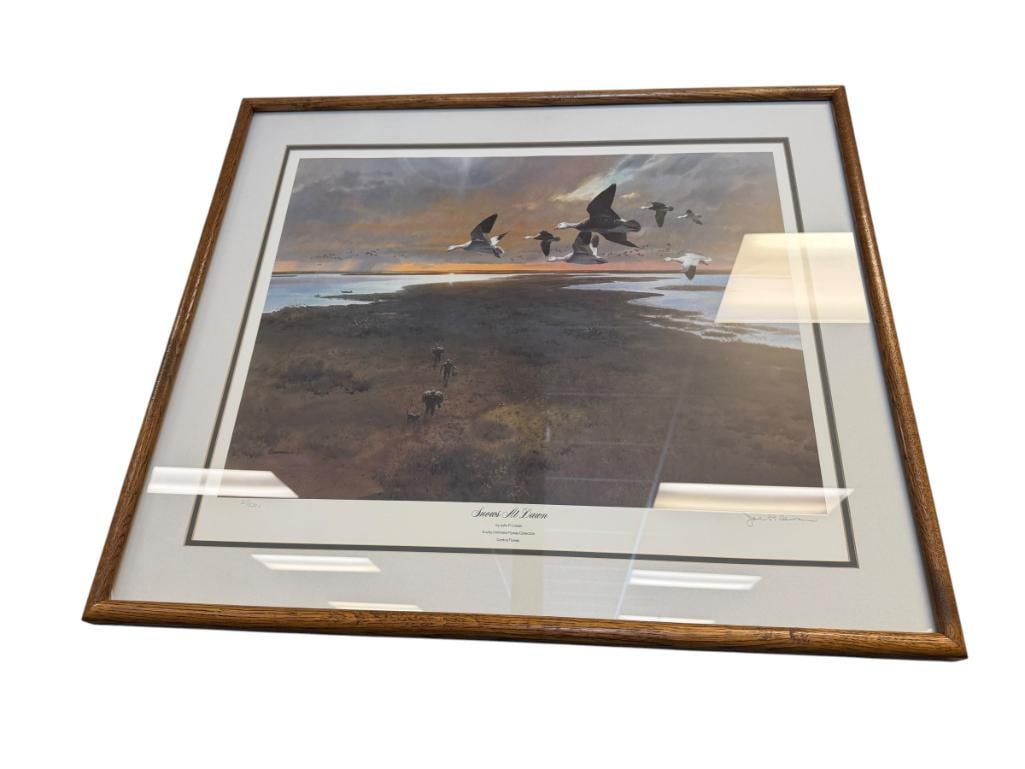 JOHN COWAN DUCKS UNLIMITED FLYWAY COLLECTION LIMITED EDITION PRINT SNOWS AT DAWN NO. 207/5300: ART DEPICTS SNOW GEESE FLYING OVER A WETLAND WITH HUNTERS BELOW, SINGED LOWER RIGHT, INFO ON BACK, FRAMED 31" X 26" FRAME