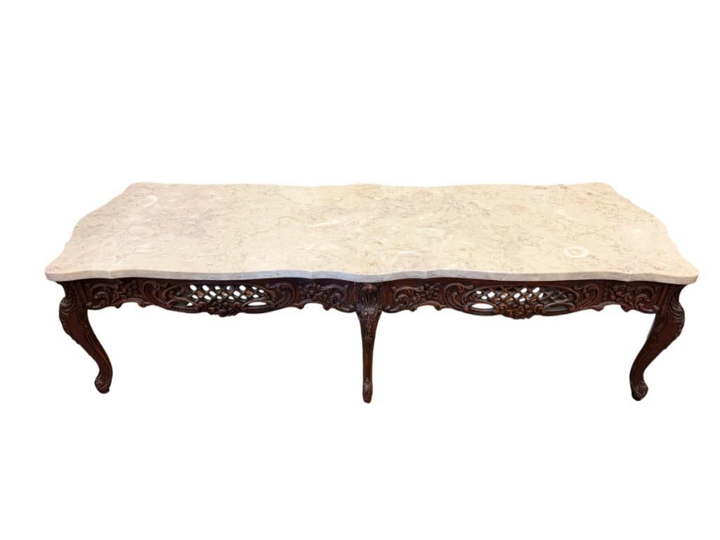 20TH CENTURY ROCOCO STYLE HAND CARVED COCKTAIL TABLE WITH STONE TOP: FLORAL AND LEAF CARVED SKIRT, BEIGE COLORED STONE TOP WITH PURPLE VEINS 55" X 20" X 15"