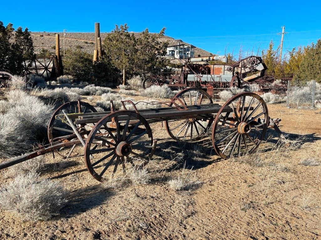 ANTIQUE 19TH CENTURY HORSE DRAWN WAGON FRAME WITH FOUR WAGON WHEELS STILL INTACT: FEATURES RUSTIC APPEAL WITH GREAT FRAME OF WAGON FROM THE OLDEN DAYS, SEEMS TO BE ORIGINAL ORANGE PATINA ON FRAME, HAS TWO SPRINGS IN CENTER TO MAKE THE RIDE EASIER BACK THEN, "K 3" MARKED ON BAR BACK
