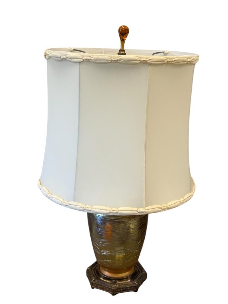 MUTUAL SUNSET LAMP CO. M.S. CO ART NOUVEAU TABLE LAMP WITH DURAND IRIDESCENT THREADED GLASS BODY: BULBOUS DURAND ART GLASS BODY WITH OCTAGONAL METAL BASE, FLORAL DECORATED, MARKED ON THE BOTTOM WITH BENJAMIN LAMP CO. FIXTURE, AMBER GLASS FINIAL WITH LINEN SHADE, PATINA FROM AGE, IN GREAT CONDITION