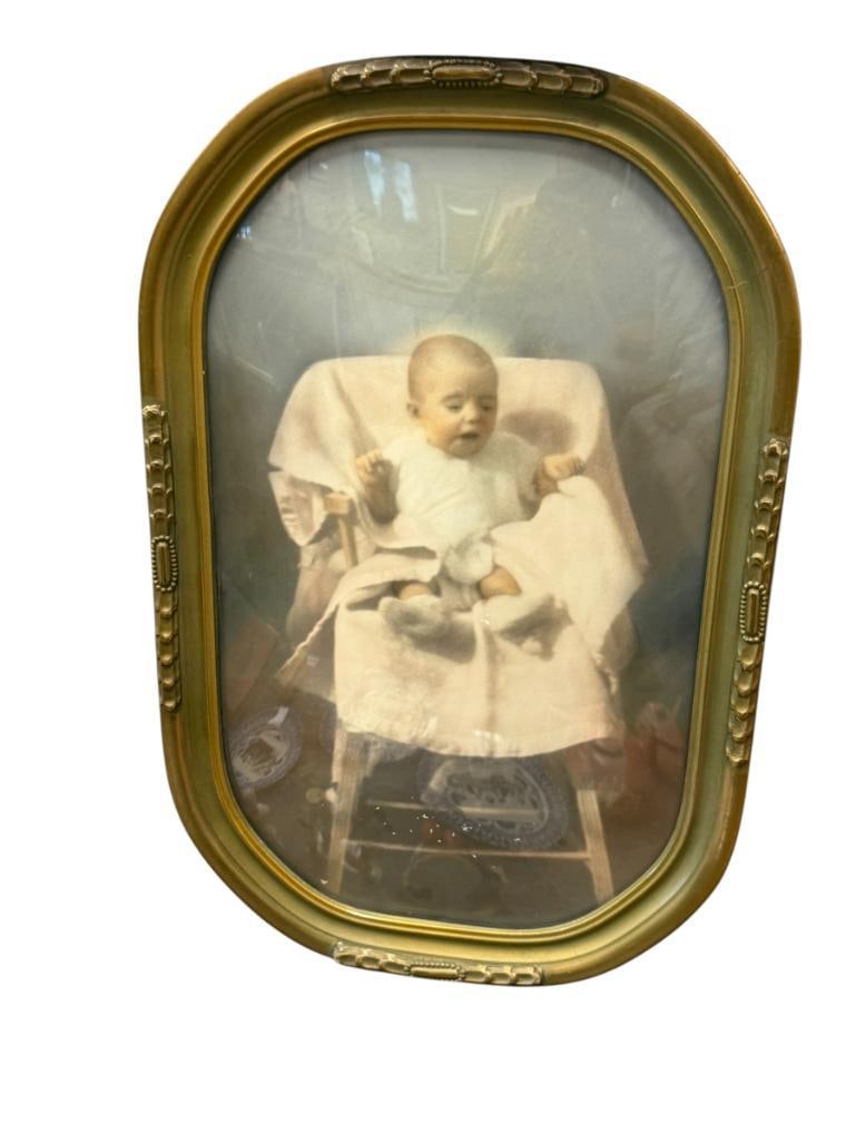 ANTIQUE HAND COLORED PHOTOGRAPH OF A BABY IN A HIGH CHAIR: CONVEX GLASS, FRAMED 11" X 17" FRAME