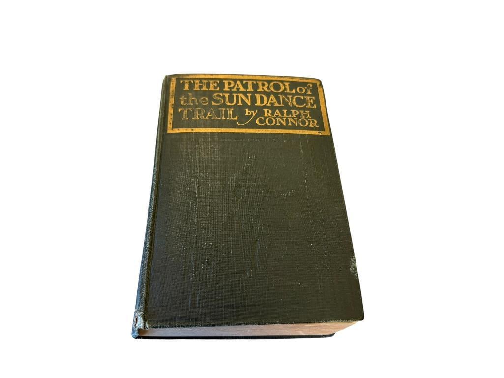 1914 THE PATROL OF THE SUN DANCE TRAIL BY RALPH CONNOR PUBLISHED BY HODDER & STOUGHTON: GREEN CLOTH COVERS WITH GILT LETTERING AND EMBOSSED SILHOUETTE ILLUSTRATION 5 1/4" X 7 1/2" 