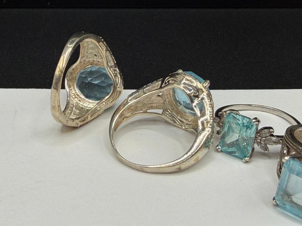 FOUR STERLING SILVER RINGS INCLUDING ONE WITH EMERALD CUT BLUE TOPAZ - 8
