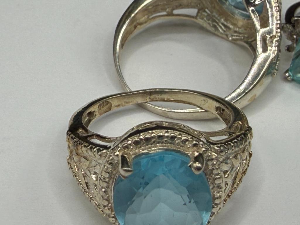 FOUR STERLING SILVER RINGS INCLUDING ONE WITH EMERALD CUT BLUE TOPAZ - 9