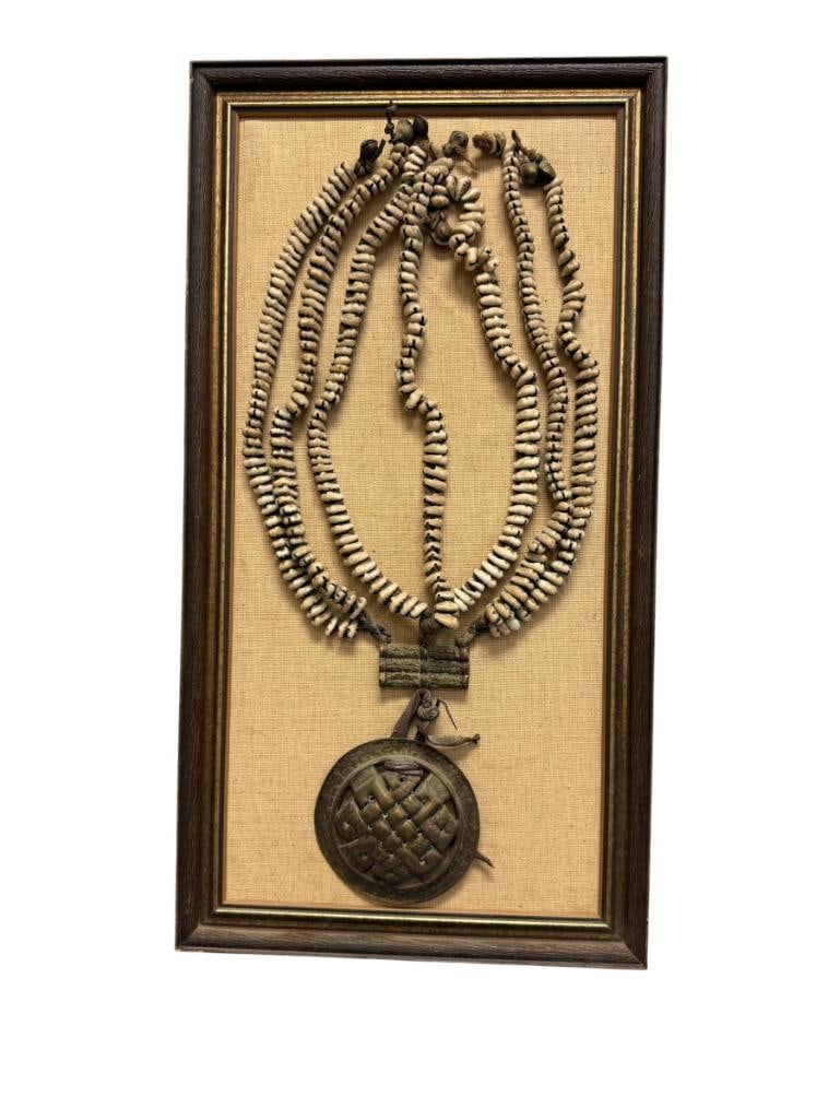 EARLY 20TH CENTURY DODCHAS / LADAKHI WOMANS WAIST ORNAMENT MADE FROM COWRIE SHELLS: FEATURES BRASS DISC IN ENDLESS KNOT DESIGN, MOUNTED IN FRAME 4" DISC, 11 1/2" X 22 1/2" FRAME