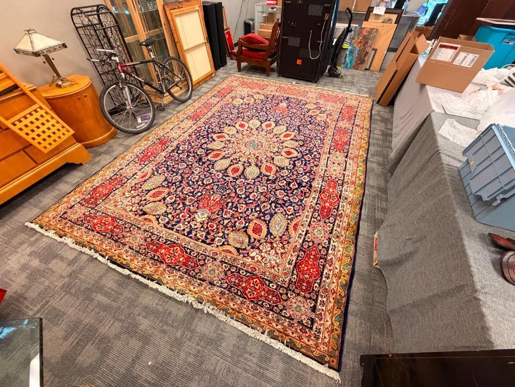 VIBRANT HAND KNOTTED PERSIAN VINTAGE WOOL PILE AREA RUG IN TRADITIONAL DESIGN MADE IN IRAN 1953: FEATURES MANY COLORS BLUE, RED, GREEN, BROWN, PINK, FEATURES A SHORT FRINGE, RUG APPEARS WELL CARED FOR WITH NO HEAVY WEAR AREAS OR FADING, DOES SHOW SOME AREAS WITH COLOR BLEEDS, NO REPAIRS, ORIGINAL