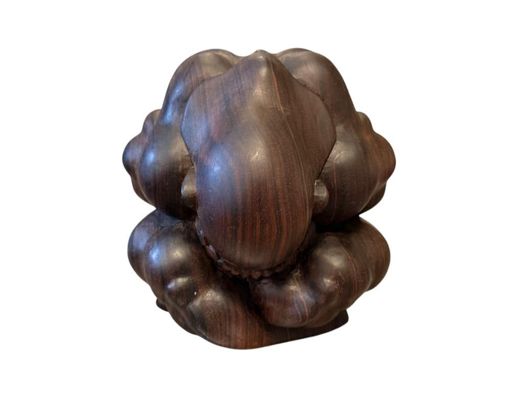 HAND CRVED ORANG MALU / WHEEPING BUDDHA SCULPTURE POSSIBLY MADE FROM SUGAR WOO SIGNED INY SUJANA: DARK CARVED EXOTIC WOOD SCULPTURE, WHEN VIEWED FROM THE BACK SCULPTURE IS TO RESEMBLE A HEART REPRESENTING LIFE AND ENERGY 5 3/4" H
