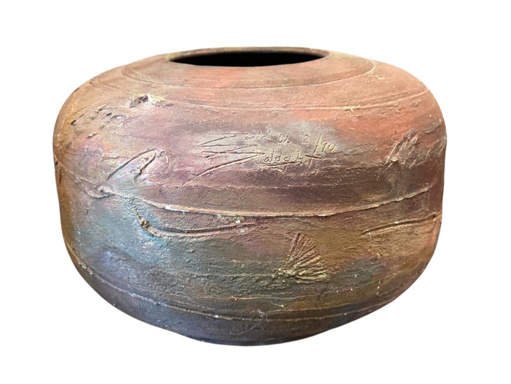LARGE SIGNED RAKU POTTERY POT IRIDESCENT WITH CARVED DESIGN: LARGE POT IS SIGNED ON THE BODY APPEARS TO BE SIGNED ZANICH W. ZALOGHT DATED 2 / 90, CARVED DESERT LANDSCAPE SCENE, NO CHIPS OR CRACKS 14" ROUND, 10" H