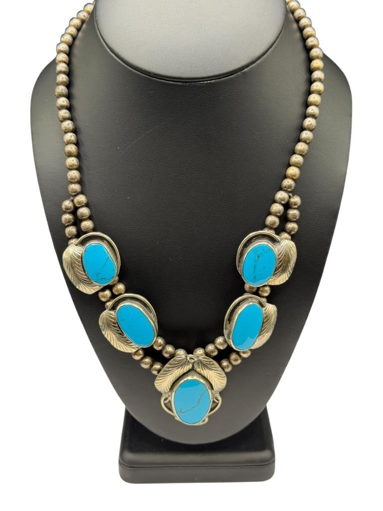 VINTAGE SILVERPLATED DYED HOWLITE SQUASH BLOSSOM NECKLACE: MARKED "HECHO EN MEXICO" AND SIGNED WITH TWO BACKWARD "S" 19", 1 5/8" CENTER BLOSSOM