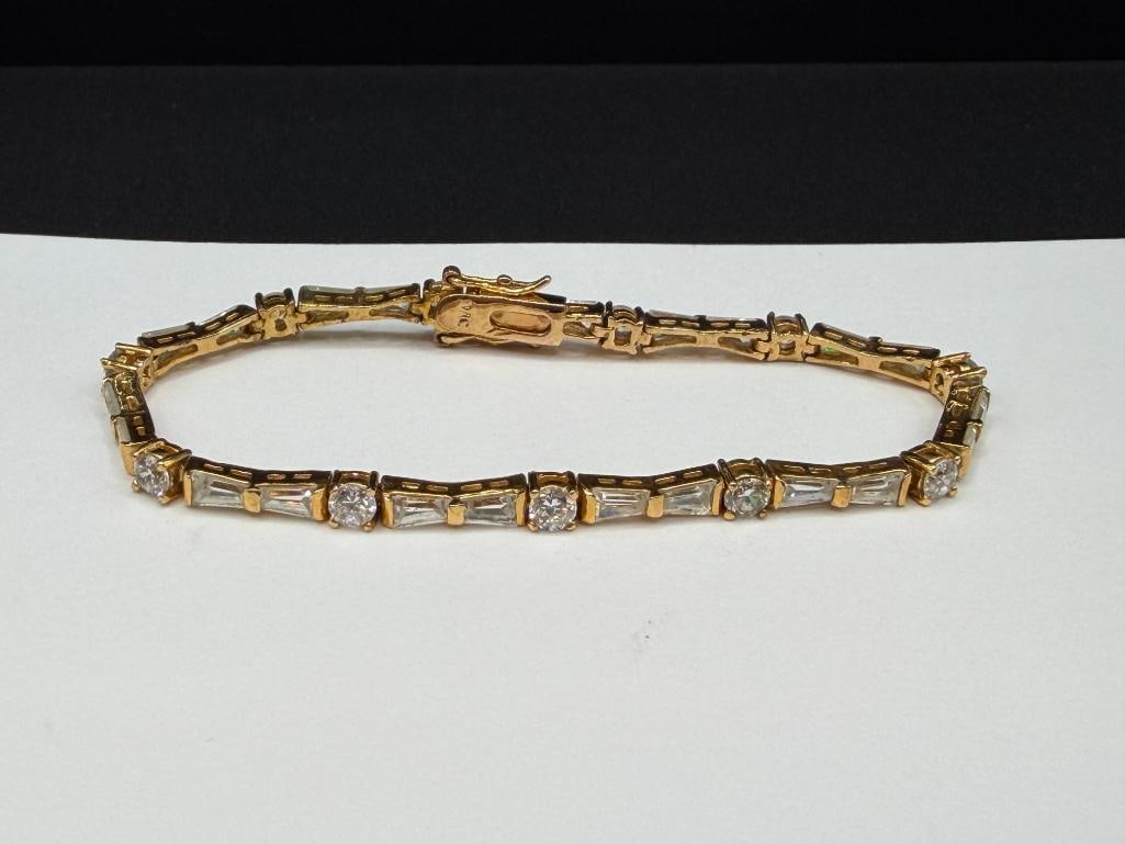 GOLD TONE CZ TENNIS BRACELET FEATURING ROUND AND BAGUETTE CUT CZ'S: SIGNED BY MAKER "JVC" 7 1/4" X 3/16" THICK, 4MM ROUND CZ'S