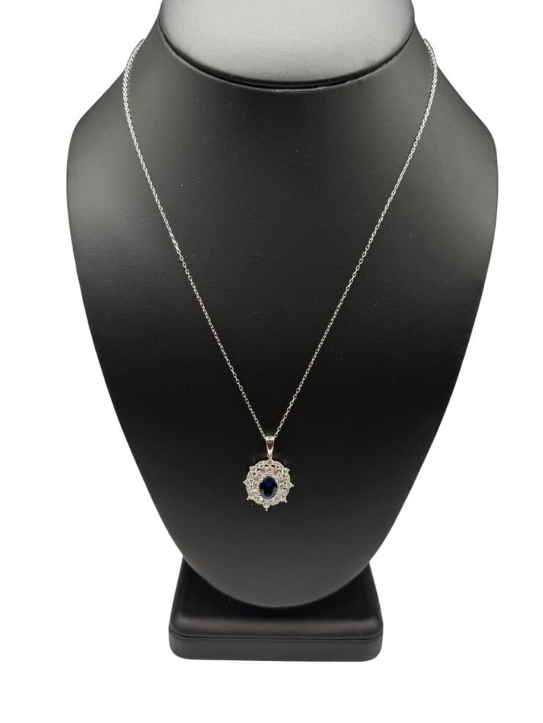 STERLING SILVER BLUE STONE AND DIAMOND PENDANT ON SILVER PLATED CHAIN NECKLACE: FEATURING AN OVAL CUT BLUE STONE ACCENTED BY ROUND AND BAGUETTE CUT DIAMONDS, DESIGNER HALLMARKED "LGD", CHAIN IS NOT SILVER 18" NECKLACE, 1" PENDANT, 4.03 GRAMS WITH CHAIN, UP TO 2.5MM DIAMONDS