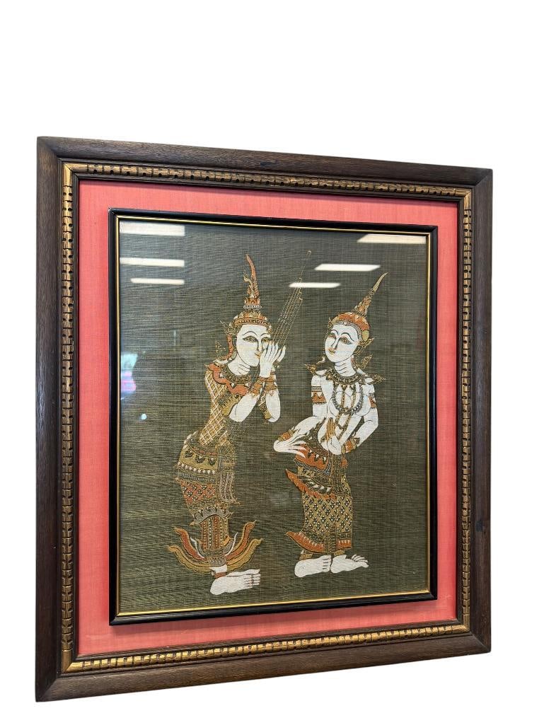 VINTAGE THAI TEMPLE RUBBING ART ON SILK KINNARA MYTHICAL CREATURES FROM BUDDHIST MYTHOLOGY: DARK GREEN BACKGROUND WITH FIGURES, CIRCA MID-20TH CENTURY, FRAMED 23" X 26" FRAME