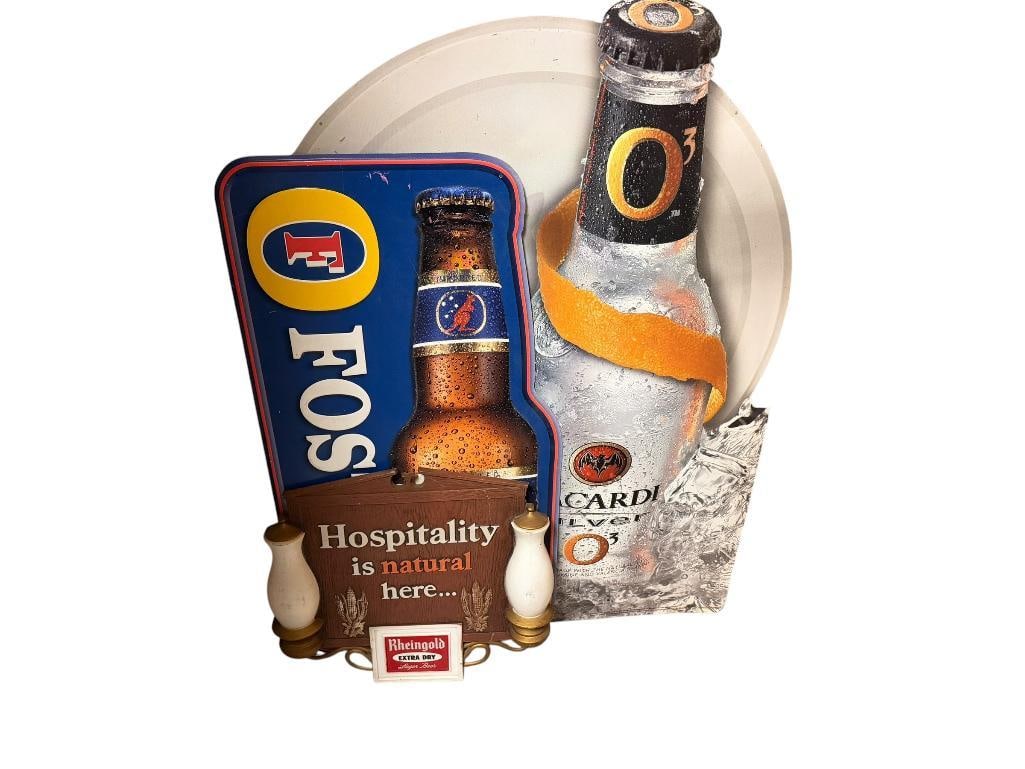 THREE BEER SIGNS INCLUDING FOSTERS TIN SIGN, BACARDI SILVER TIN SIGN, AND VINTAGE RHEINGOLD LAGER: RHEINGOLD SIGN IS HARD PLASTIC, ALL IN PRETTY GOOD CONDITION WITH SOME SCUFFS LARGEST IS 36" H