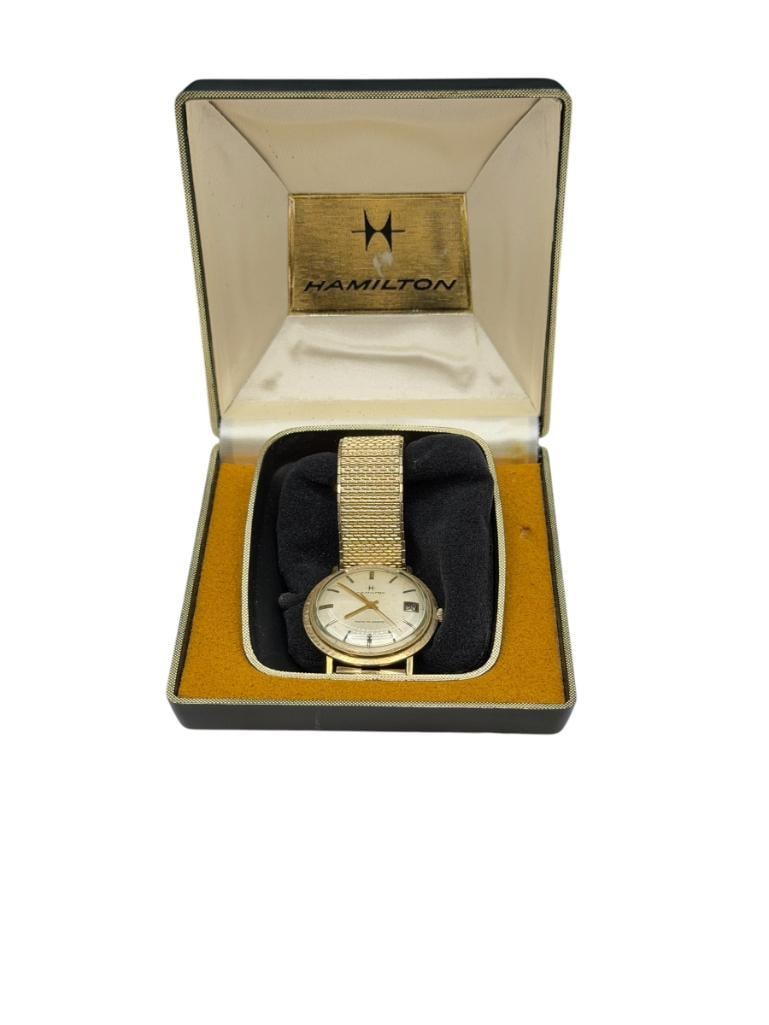 VINTAGE 1960'S MEN'S HAMILTON THIN-O-MATIC AUTOMATIC SELF WINDING WRISTWATCH: FEATURING GOLD TONE FINISH AND GOLD FILLED CASE, DATE ADJUST, IN RUNNING CONDITION, BAND BY SPEIDEL, INCLUES ORIGINAL BOX AND CERTIFICATION OF QUALITY BOOKLET 34MM CASE