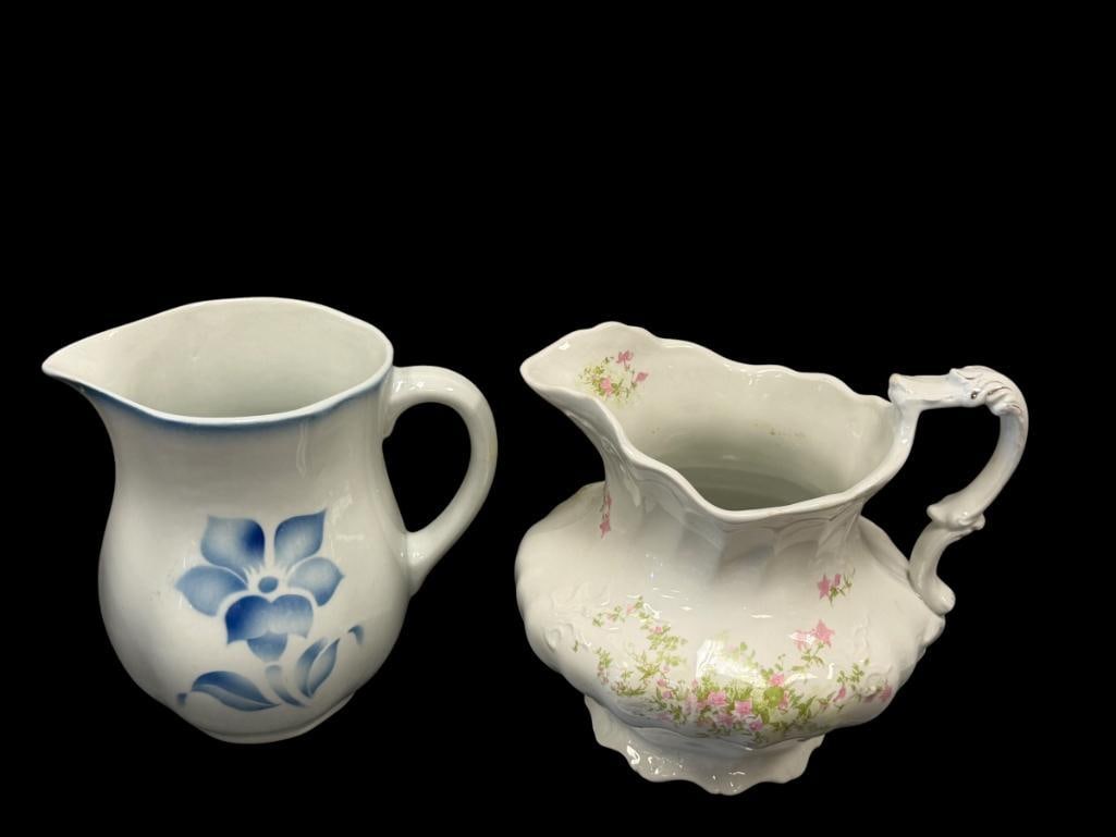 20TH CENTURY ENGLISH POTTERY PITCHERS NEW WHARE / ARABIA: ONE FEATURES BLUE FLORAL STENCIL DESIGN, OTHER WITH PINK TRANSFER DECORATED DESIGN, BOTH MARKED ON THE BOTTOM, ARABIA PITCHER HAS SMALL DEFECT ON THE BOTTOM OF THE SPOUT 7" AND 8" H