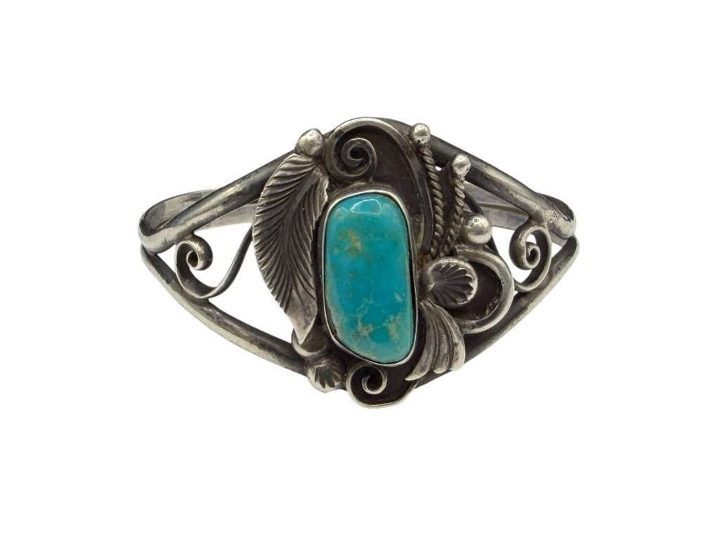 VINTAGE NAVAJO D & J CLARK ARTIST STERLING SILVER TOOLED SILVER TURQUOISE CUFF BRACELET: FEATURING FIGURAL FEATHER, BLOSSOM, AND SCROLL DESIGN, SIGNED BY ARTIST DELBERT CLARK AND HIS WIFE JANETTE CLARK 2 1/4" CUFF WRIST WIDTH, 1 3/8" FRONT, 19MM TURQUOISE, 22.65 GRAMS
