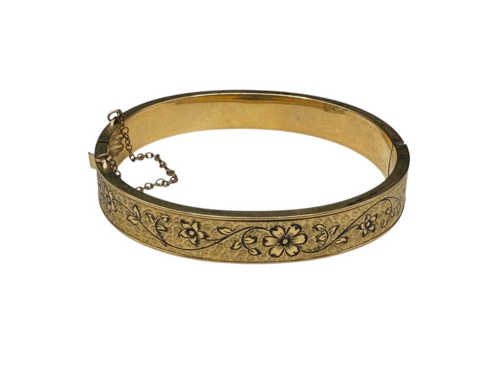ANTIQUE FINBERG DESIGNER SIGNED 12K GOLD FILLED BANGLE BRACELET: SIGNED F.M. CO. BY DESIGNER, HINGED DESIGN WITH SAFETY CHAIN, ORNATE FLORAL DESIGN WITH BLACK HIGHLIGHTS 2 1/4" BANGLE WRIST WIDTH X 1/2" THICK, 13.86 GRAMS
