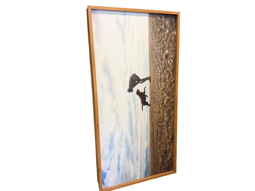 FIVE OVERSIZED PHOTOGRAPHIC ART ON BOARD INCLUDING LANDSCAPE SCENES AND PEOPLE NEAR BODIES OF WATER: ART FEATURES BIRDSEYE IMAGE OF AN ISLAND, WOMAN PLAYING WITH LABRADOR BY A LAKE, WOMAN LAYING NEAR RIVER, ETC. FRAMED 73" X 38" FRAMES