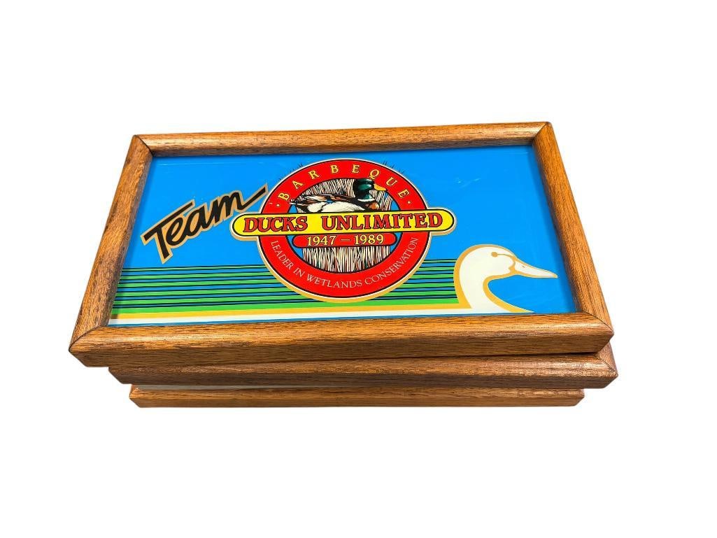 1987, 1989, 1992, AND 1994 NEVADA BIGHORNS UNLIMITED AND RENO DUCKS UNLIMITED GLASS SIGNS WITH OAK: ALL FRAMES ARE OAK BESIDES ONE METAL FRAME LARGEST ARE 16" X 9"