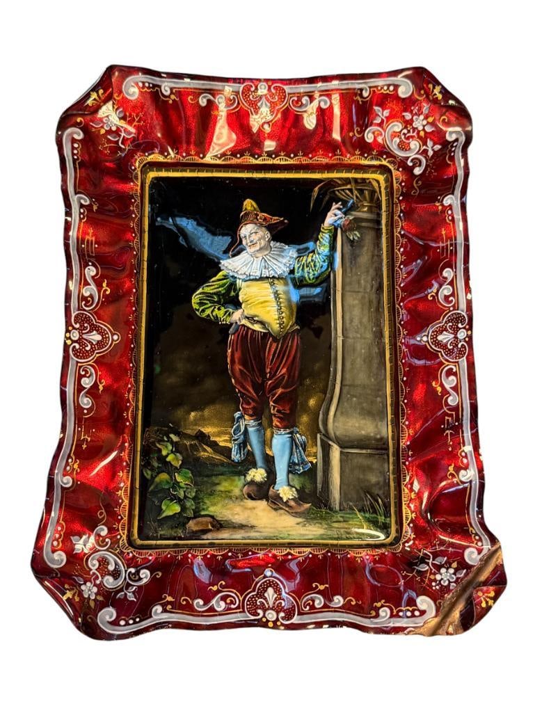 19TH CENTURY LIMOGES FRENCH HAND ENAMELED ON COPPER PLATE THEOPHILE SOYER: RUFFLED EDGE COPPER PLATE, HAND ENAMELED WITH VIBRANT IMAGE OF JESTER STANDING NEAR A WALL WITH LEAVES ALONG THE GROUND, DECORATIVE WHITE AND GILT BORDERS, ENAMELING DOES HAVE SOME DAMAGE MORE