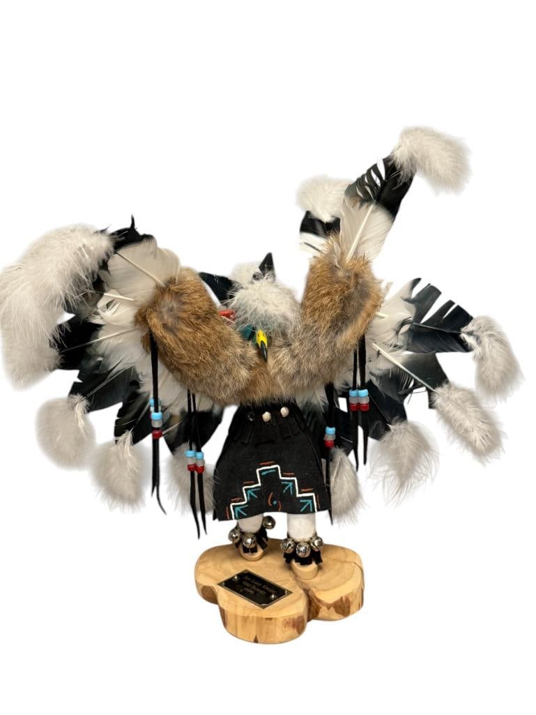 VIRGINA BEGAY NAVAJO ARTIST COTTON WOOD KACHINA DOLL EAGLE WITH BIRD FEATHERS AND ANIMAL FUR: LARGE KACHINA DOLL CRAFTED BY VIRGINIA BEGAY, MOUNTED ON WOOD BASE, HAS ENGRAVED PLAQUE "SUN LAKES KIWANIS GOLF TOURNEY 1999" MAY HAVE BEEN AN AWARD FROM A GOLF TOURNAMENT, SIGNED ON THE BOTTOM, MISSI