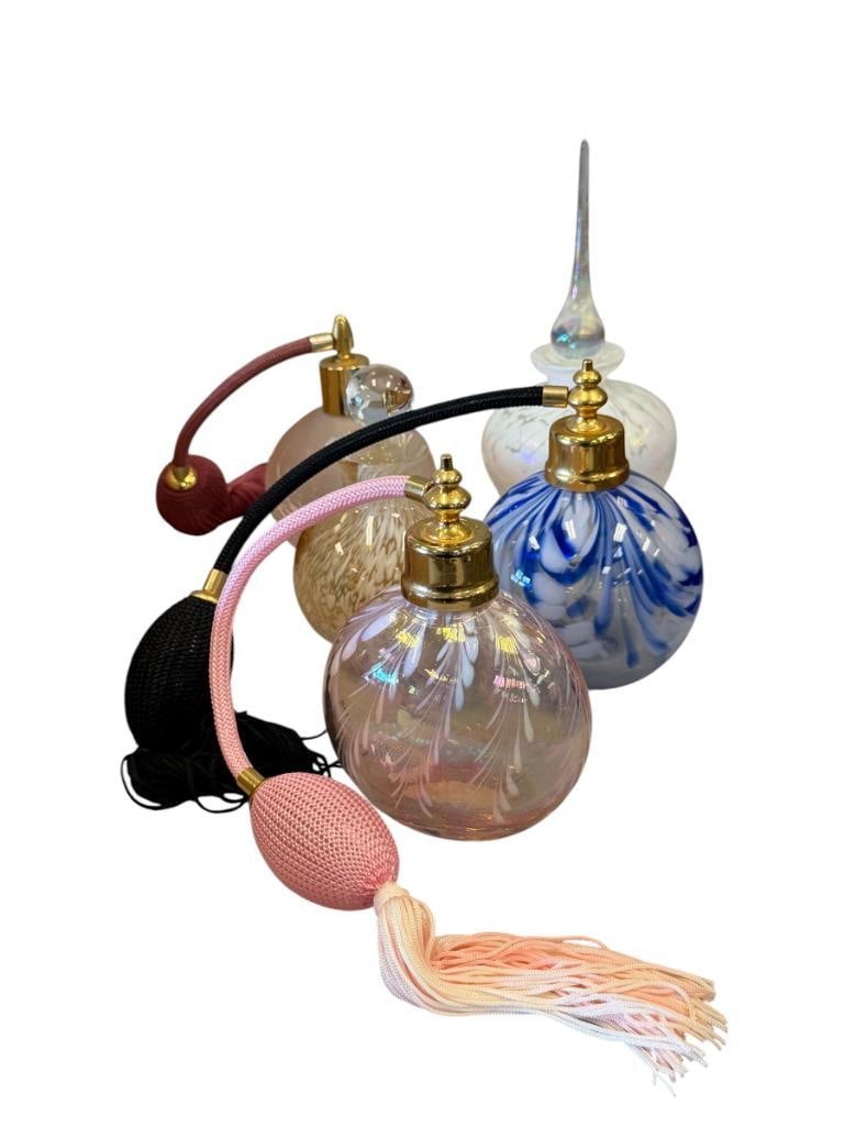 HAND BLOWN ART GLASS FRAGRANCE BOTTLES THREE WITH STOOMIZERS: GROUP INCLUDES THREE IRIDESCENT BOTTLES, TWO WITH STOPPERS, AND THREE WITH ATOMIZERS, ONE ATOMIZER IS HARDENED AND DOES NOT WORK, OTHERS ARE FUNCTIONAL 4 1/2" UP TO 6 1/2" H