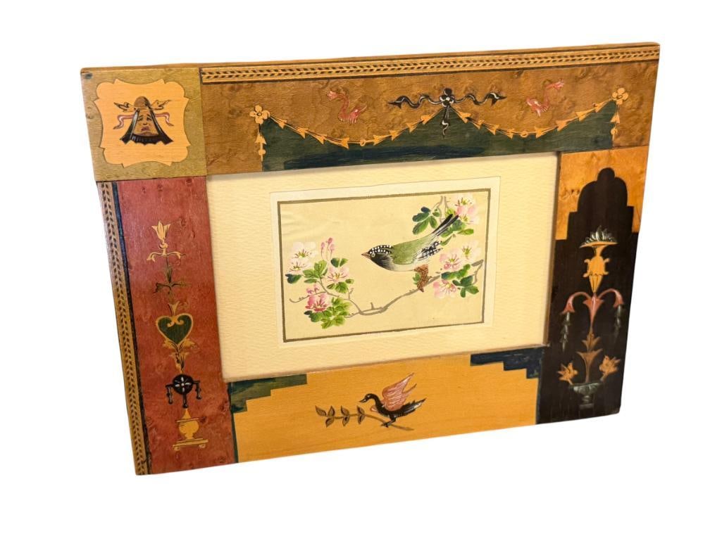 20TH CENTURY ORIGINAL MINIATURE PAINTING ON SILK OF PERCHED BIRD AND FLOWER IN INTRICATE FRAME: MINIATURE PAINTING ON SILK OF A BIRD PERCHED SURROUNDED BY PINK FLOWERS, IN INTRICATE MIXED WOOD FRAME WITH NEOCLASSICAL DESIGN 8 1/8" X 6 1 /4" FRAME