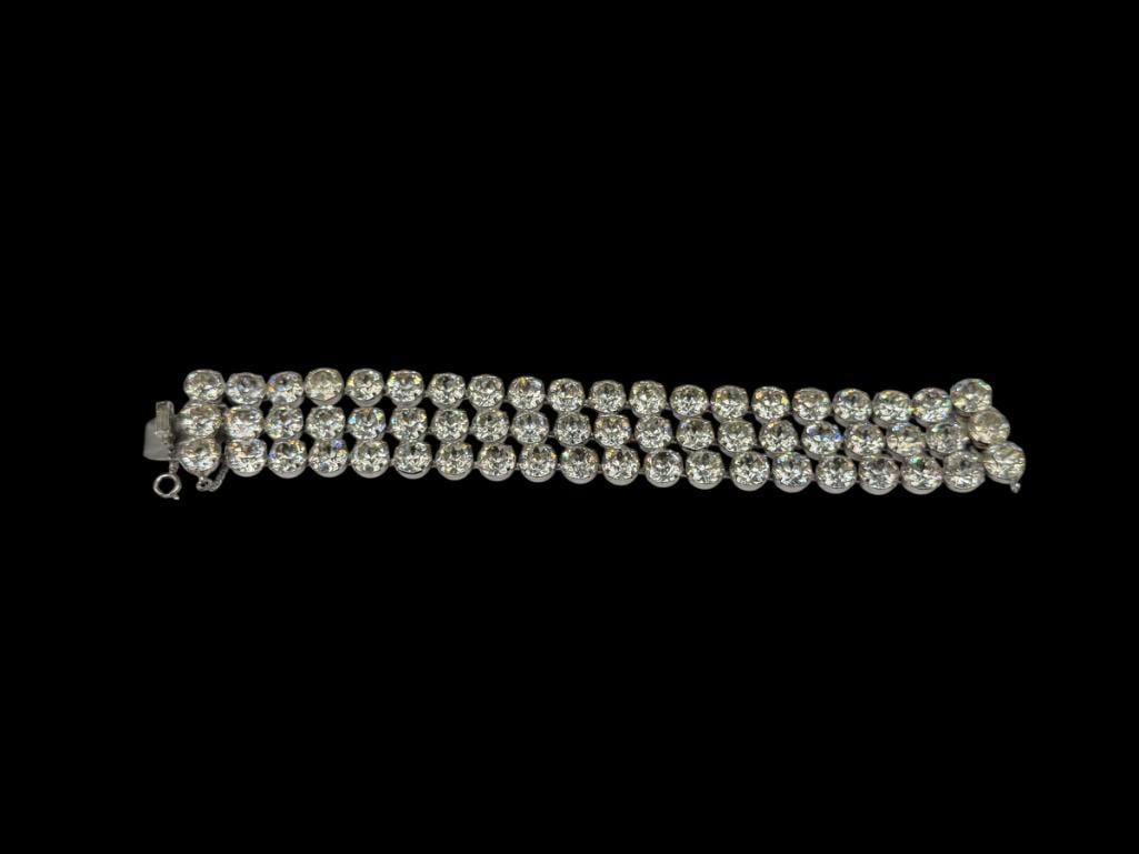 EISENBERG SIGNED COSTUME JEWELRY RHINESTONE MULTI-STRAND BRACELET: THREE STRAND DESIGN FEATURING ROUND CUT RHINESTONES, SIGNED ON CLASP, INCLUDES SAFETY CHAIN 7 1/4" X 1", 9MM RHINESTONES
