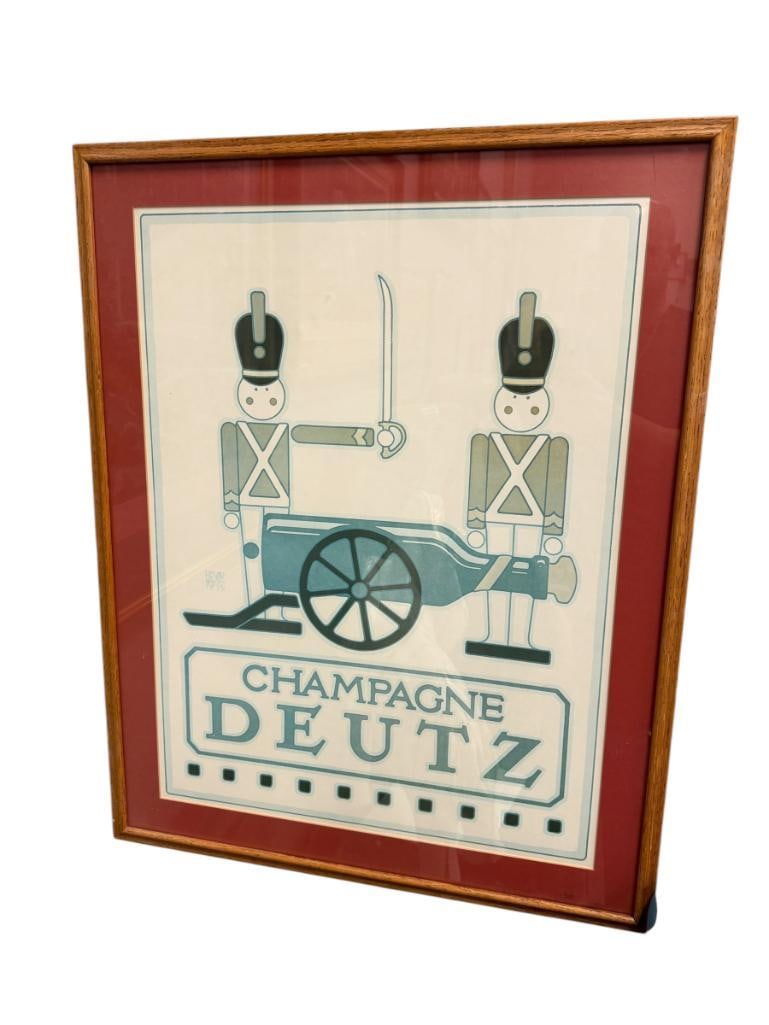 1975 LITHOGRAPH POSTER CHAMPAGNE DEUTZ BY ARTIST DAVID LANCE GOINES: ART DEPICTS TWO STYLIZED TOY SOLDIERS FIRING A CHAMPAGNE BOTTLE, COMMISSIONED BY CONNOISSEUR WINE IMPORTS, PLATE SIGNED, POSTER DOES SHOW FADING, FRAMED 24 1/2" X 31" FRAME