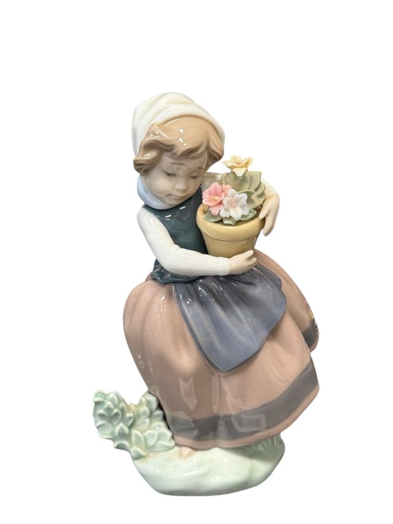 LLADRO FINE PORCELAIN FIGURINE SPIRNG IS HERE NO. 5223 RELEASED IN 1980'S: DEPICTS YOUNG GIRL WEARING A BONNET WITH FLOWERS,MARKED ON THE BOTTOM, MADE IN SPAIN, ONE FLOWER IS DAMAGED 6 3/4" H