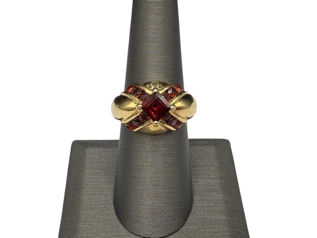 14K YELLOW GOLD DESIGNER SIGNED PRINCESS CUT GARNET FASHION RING: ACCENTED WITH 12 ROUND CUT GARNETS, DESIGNER SIGNED JBNI SIZE 7 1/4, 5/8" FRONT, 6MM CENTER GARNET, OTHERS ARE 3MM, 7.83 GRAMS