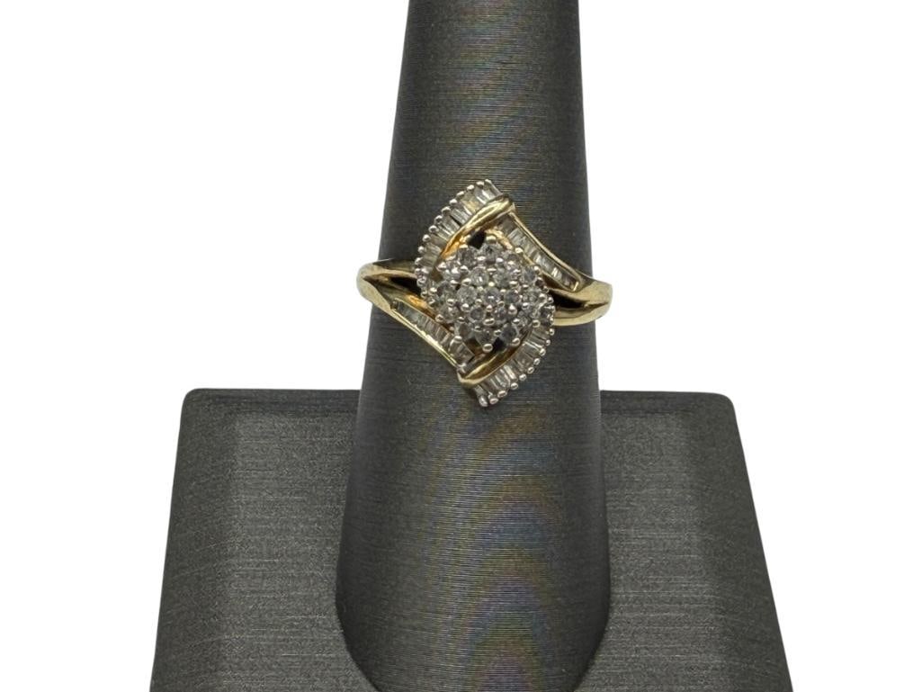 10K YELLOW GOLD ROUND AND BAGUETTE CUT DIAMOND RING FEATURING MARQUISE SHAPE DESIGN: RING FEATURES A CLUSTER OF 19 ROUND BRILLIANT CUT DIAMONDS IN CENTER ACCENTED BY BANDS OF BAGUETTE CUT DIAMONDS, DESIGNER HALLMARKED, SIZE 7 1/4, 11/16" FRONT, 1MM DIAMONDS, 2.89 GRAMS