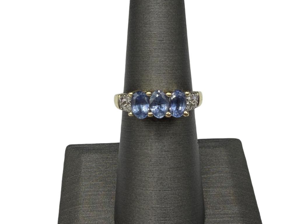 14K YELLOW GOLD OVAL CUT TANZANITE AND DIAMOND RING: FEATURING THREE OVAL CUT TANZANITES ACCENTED BY EIGHT ROUND BRILLIANT CUT DIAMONDS, DESIGNER SIGNED "STS" SIZE 6 1/4, 6MM X 4MM TANZANITES, 1MM DIAMONDS, 3.06 GRAMS