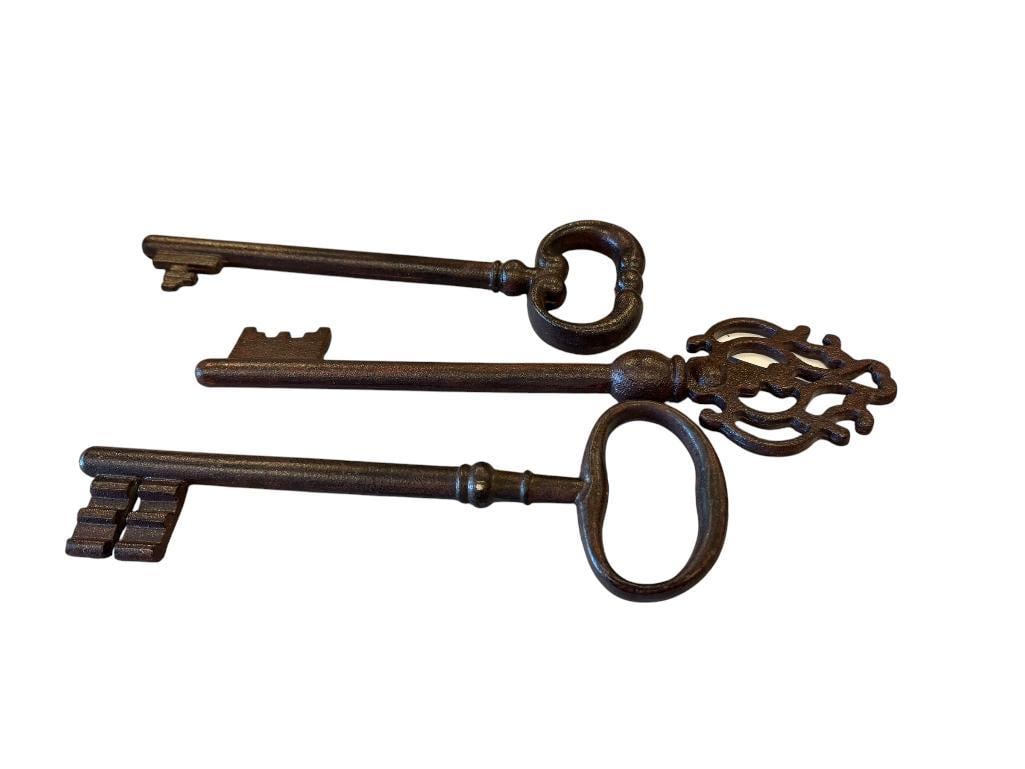 THREE DECORATIVE BRONZE TONED CAST IRON SKELETON KEYS: TWO FEATURE LOOP HANDLES, OTHER HAS DECORATIVE HANDLE 12" AND 13" L