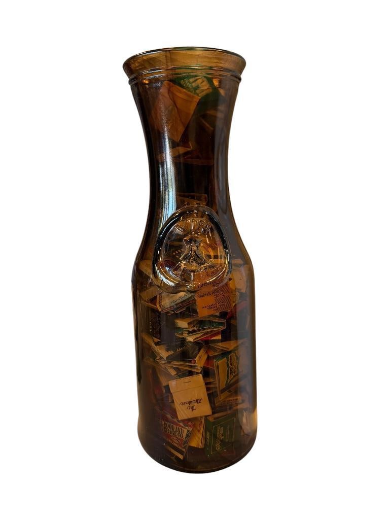 VIN LITRE EMBOSSED BROWN GLASS BOTTLE FILLED WITH MANY MATCHBOOKS: INCLUDES MATCHBOOKS FROM MANY DIFFERENT ESTABLISHMENTS, HOTELS, CASINOS, RESTAURANTS 18 1/4" H