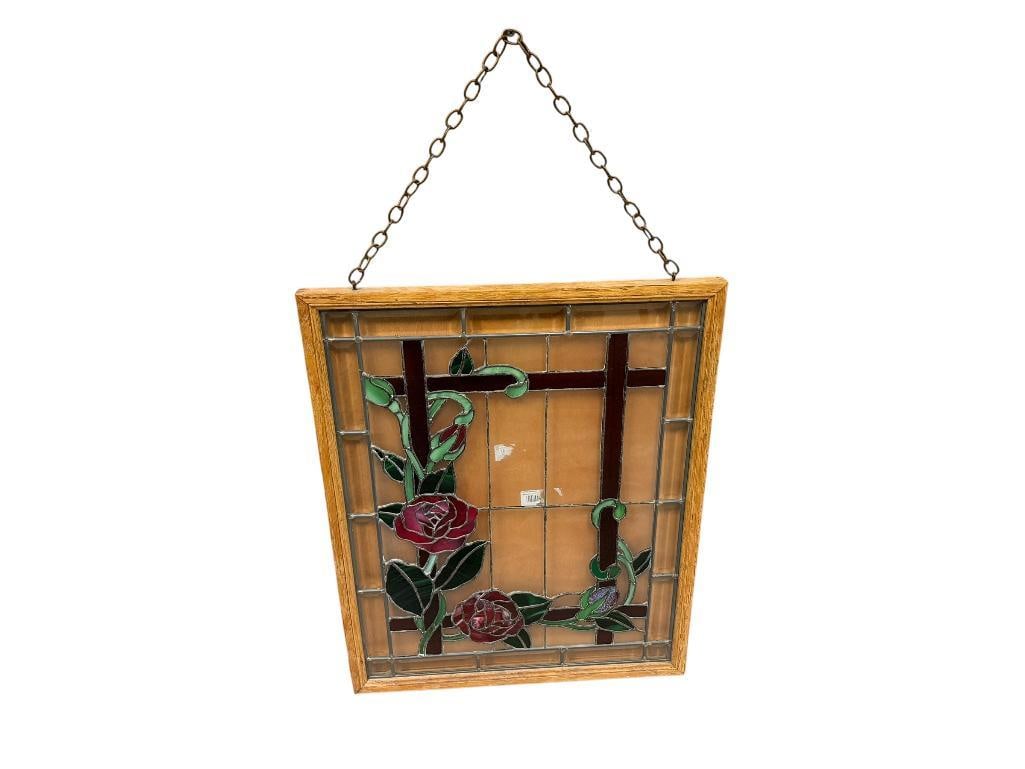 VINTAGE STAINED GLASS WINDOW PANEL IN OAK FRAME FEATURING ROSE FLORAL DESIGN: FEATURING RED, GREEN, AND PURPLE STAINED GLASS, METAL CHAIN LINK FOR HANGING, BEVELED GLASS BORDER, APPEARS TO BE FREE OF CHIPS AND CRACKS 20" X 25" FRAME