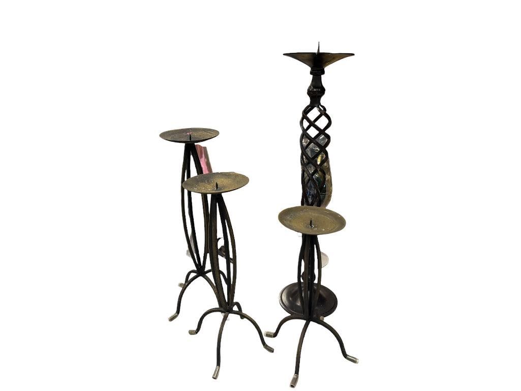 FOUR BENT IRON CANDLESTICKS INCLUDING A SET OF THREE WITH GRADUATED HEIGHT: EACH WITH SPIKE FOR WAX CANDLES LARGEST IS 19" H