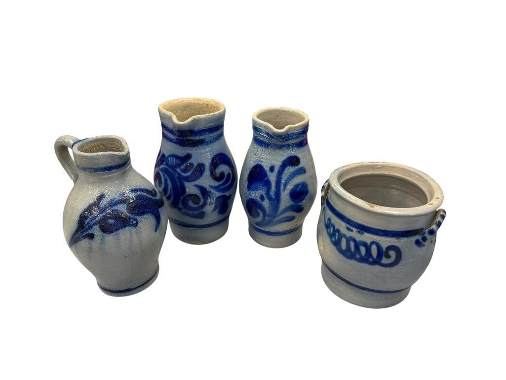 FOUR PIECES OF WESTERWALD GERMAN SALT GLAZED POTTERY INCLUDING THREE PITCHERS AND ONE CROCK: EACH FEATURES FLORAL BLUE DESIGN, MINOR FLAWS IN POTTERY LARGEST IS 8 1/4"