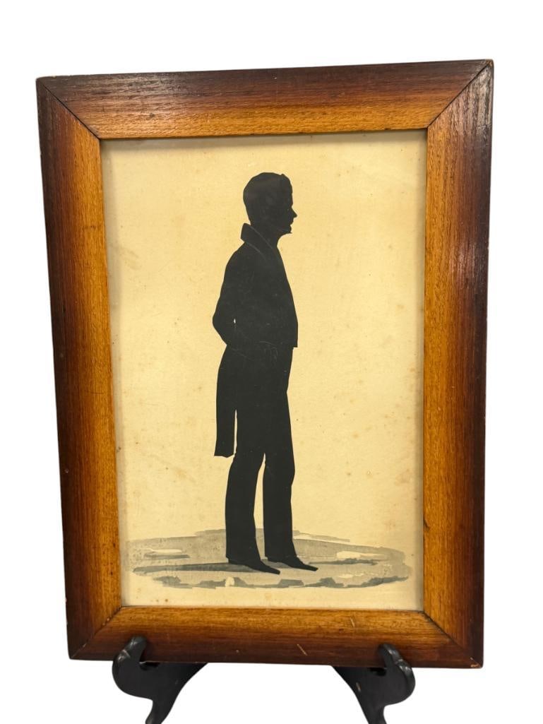 19TH CENTURY STANDING SILHOUETTE BY DAVIS C. HAMMOND CIRCA 1840: ART DEPICTS A STANDING SILHOUETTE OF A GENTLEMAN DATED 1840, INFORMATION WRITTEN ON THE BACK READS "GIVEN TO IDA THE OLDEST LIVING OF D.C.H. BY HIS COUSIN LYDIA HERSHEY IN THE YEAR OF 1890", FRAMED 10