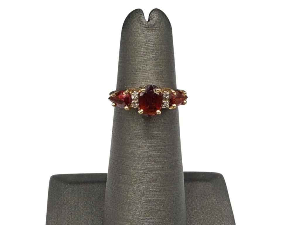 14K YELLOW GOLD GARNET AND DIAMOND FASHION RING: FEATURING AN OVAL CUT AND TWO PEAR CUT GARNETS ACCENTED BY FOUR ROUND CUT DIAMONDS SIZE 4, 1/4" FRONT, 2.40 GRAMS, APPROX. 1.50CTTW GARNETS, 1MM DIAMONDS